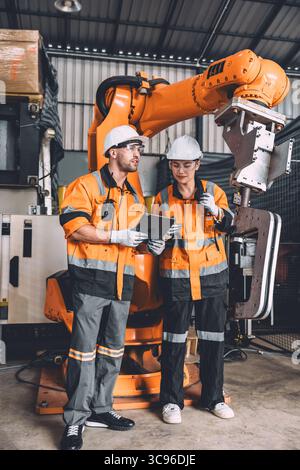 Engineer team service robot welding working in automation factory. People workers safety work control robot machine in heavy industry technology. Stock Photo