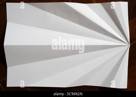 Unfolded Paper Plane Creating Bold Black and White Radiating Design Stock Photo