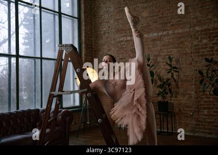 A graceful ballet pose captured in an elegant ambient interior setting with stylish decor Stock Photo