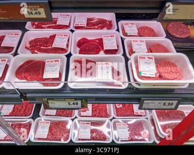Italy - August 4, 2025: Beef steaks, hamburgers, and ground beef vacuum-packed in white plastic trays displayed in refrigerated cases for sale at Lidl Stock Photo
