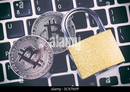 Bitcoin cryptocurrency with padlock on keyboard. Close up image. Stock Photo