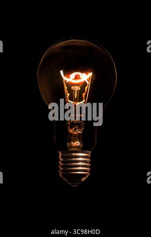 Glowing light bulb without wires on black background. Stock Photo