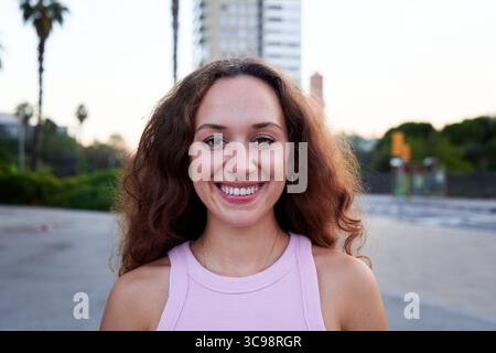 Young woman smiling outdoors in urban city setting. Stock Photo