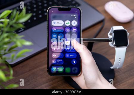 Poznan, Poland - July 29, 2025: A hand manipulates digital controls on a smartphone, featuring responsive ios 26 software and a vivid Liquid Glass dis Stock Photo