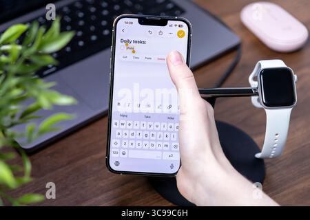 Poznan, Poland - July 29, 2025: Daily tasks app on a futuristic smartphone, featuring ios 26 and Liquid Glass screen, used for modern digital producti Stock Photo