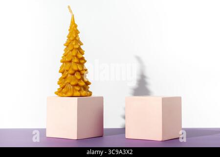 Podiums and curly candle on a white background. Two cubic podium Christmas tree. Mockup for demonstrating cosmetic products. Copy space Stock Photo