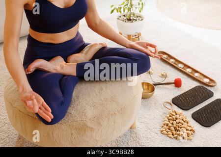 Woman meditating in lotus pose at home practicing yoga and mindfulness for healthy balanced lifestyle Stock Photo