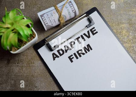 Concept of Adaptive Firm write on clipboard isolated on Wooden Table. Stock Photo
