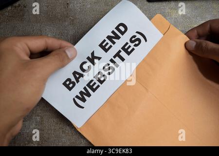 Back end websites text above brown envelope programming of internet website isolated on wooden background. Coding cyberspace concept Stock Photo