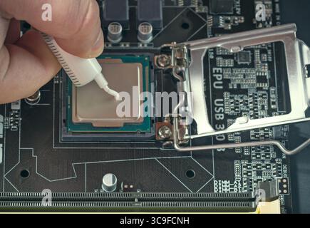 Applying thermal paste during CPU installation close up in the motherboard. Stock Photo