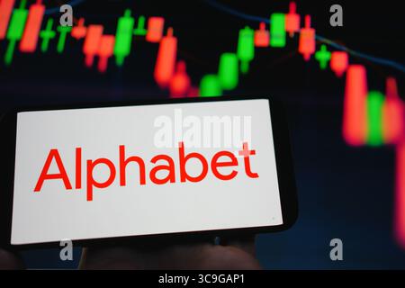 Roosendaal, The Netherlands - August 05, 2025: A mobile phone displaying the company logo of Alphabet, with a stock chart in the background. Stock Photo