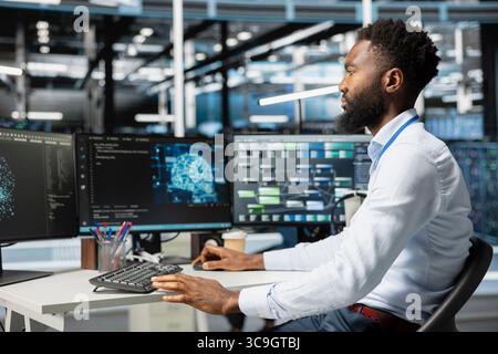 Computer scientist inspecting neural network data center used for machine learning. African american man doing maintenance on server hub to optimize it for artificial intelligence workloads Stock Photo