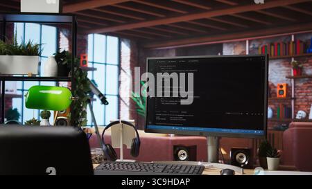 Code typed into PC entering commands and running script, panning shot of monitor on desk. Computer display in apartment used for fixing errors in application and implementing features Stock Photo