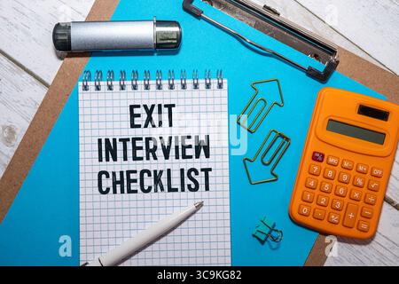 Handwritten Exit Interview Checklist Message On Notebook With Blue Marker And Spectacles Over Office Desk Stock Photo