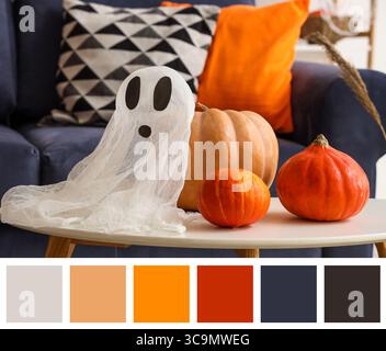 Table with ghost and pumpkins in room decorated for Halloween. Different color patterns Stock Photo