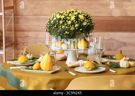 Autumn table setting with chrysanthemum flowers and pumpkins Stock Photo