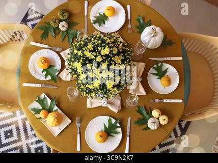 Autumn table setting with chrysanthemum flowers and pumpkins, top view Stock Photo