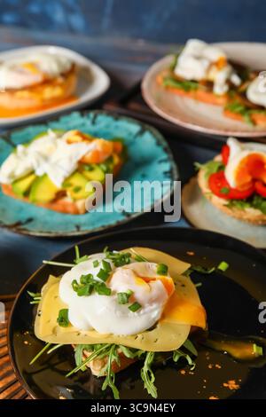 Plates with tasty eggs Benedict on table Stock Photo