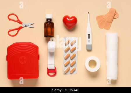 Composition with first aid kit, thermometer, pills and medical supplies on beige background Stock Photo