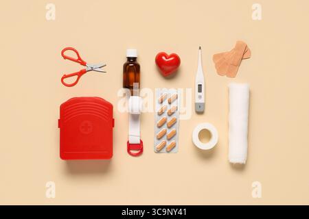 Composition with first aid kit, thermometer, pills and medical supplies on beige background Stock Photo