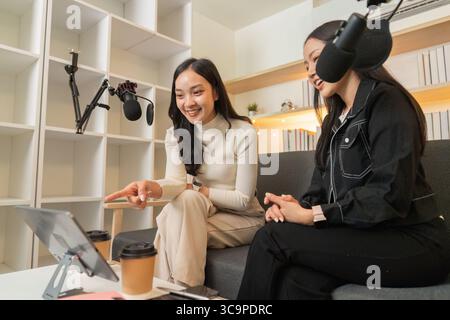 Podcasting. Two women engaged in a lively conversation while recording. Stock Photo