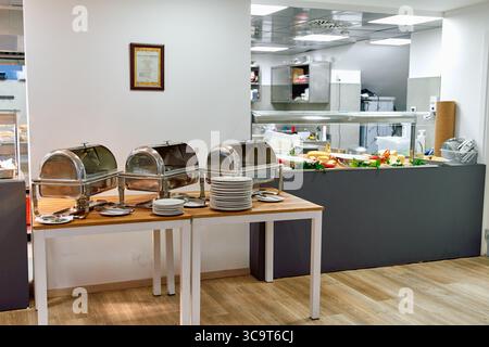 A Welcoming Setup of Buffet Stations with Elegant Chafing Dishes Ready for Guests in a Modern Culinary Space Stock Photo