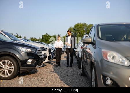 Car Dealer Shows Car To Customer Stock Photo