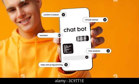 Young man showcasing a smartphone displaying a chatbot interface and features with a vibrant orange background Stock Photo