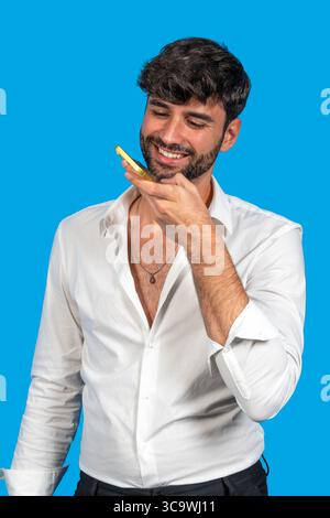 Man interacting with smartphone using voice command against blue background Stock Photo