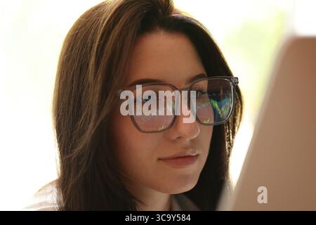 Young woman wearing glasses with reflection indoors, closeup Stock Photo