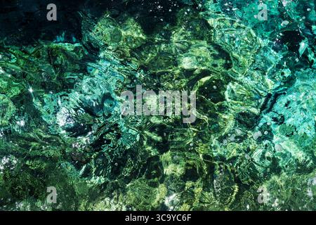 View from the bottom of the sea through slightly blurred green-blue water shimmering in the sun, Santorini, Greece Stock Photo