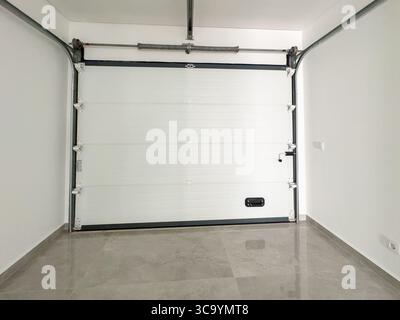 White automatic garage door with a motorized opener and metal support system. Stock Photo