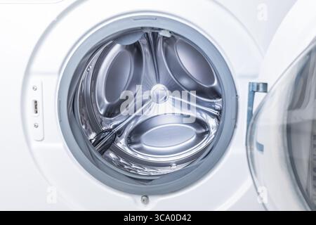 Empty washing machine with open door in laundry room Stock Photo