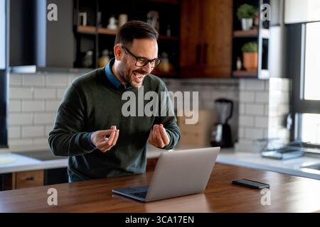 Success man typing on laptop, communicating online distantly working or studying on computer at home Stock Photo