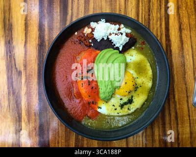 December 17, 2022, Oaxaca, Oaxaca, Mexico: Huevos Divorceados or Divorced Eggs, a traditional Mexican breakfast dish in a restaurant in Oaxaca, Mexico.  Two fried eggs are covered in red and green salsas, separated on different sides of the plate and garnished with refried black beans with queso fresco and avocado slices. (Credit Image: © Jon G. Fuller / Vwpics/VW Pics via ZUMA Press Wire) Stock Photo