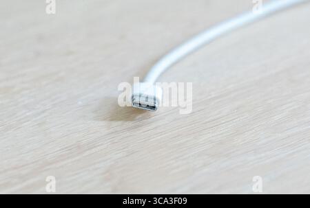 August 2025 White iPhone USB-C cable plug close up on a table Stock Photo