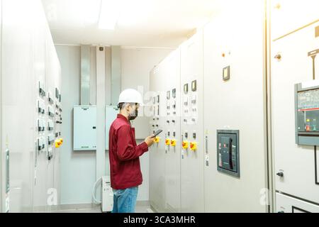 The engineer checking and inspecting at MDB panel .he working with electric switchboard to check range of voltage working in Main Distribution Boards Stock Photo