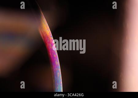 Minimalist Macro of Iridescent Soap Bubble Edge with Large Copy Space on Dark Background Stock Photo
