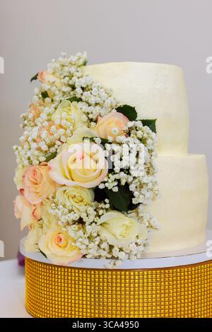 Beautifully decorated two tier cake features delicate roses baby's breath, perfect for festive occasion. Stock Photo