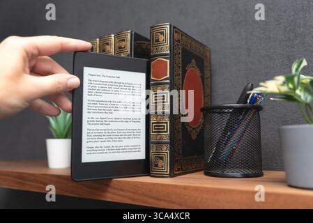 E-book reader device on shelf in home library Stock Photo