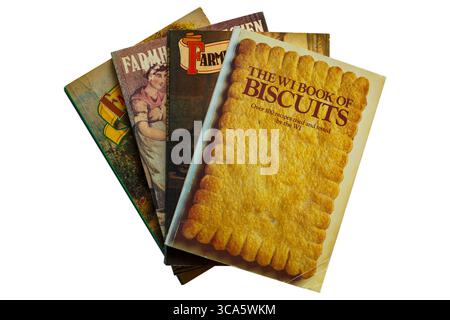Selection of old vintage paperback books with The WI book of Biscuits book on top set on white background, over 100 recipes tried and tested by the WI Stock Photo
