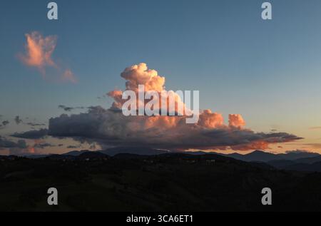 A breathtaking sunset illuminates the sky with dramatic fiery orange and red stratocumulus clouds. Stock Photo