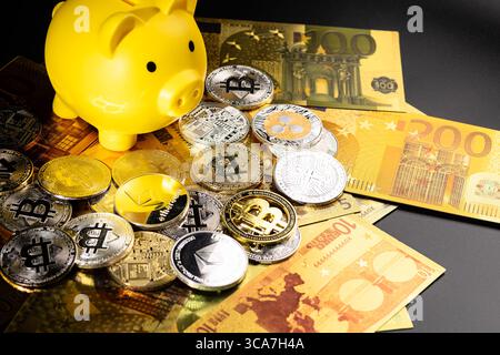 A yellow piggy bank surrounded by silver and gold Bitcoin coins on a black surface. The image symbolizes digital currency, financial savings, and inve Stock Photo