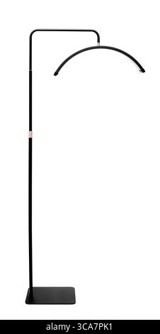 A modern black floor lamp with a curved head and a rectangular base on white. Stock Photo