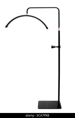 A modern black floor lamp with a curved head and a clamp on the pole. Stock Photo