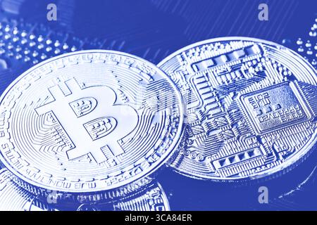 Bitcoins on computer motherboard. Bitcoin btc cryptocurrency on computer circuit board. Macro shot. Toned image. Stock Photo