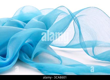 Transparent blue fabric draped in waves on white background Stock Photo