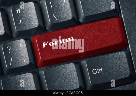 Close-up view of conceptual black keyboard. Red button with inscription FORUM. Internet forum and discussion concept Stock Photo