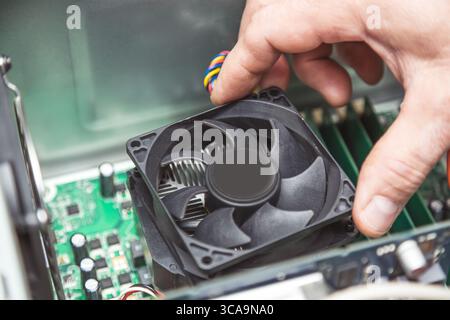 Technician hands installing CPU cooler fan on a computer pc motherboard. Stock Photo