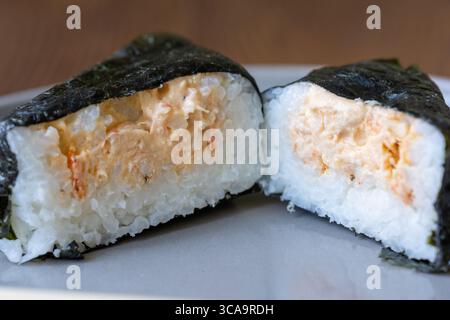 onigiri on a white plate on the table in close-up Stock Photo